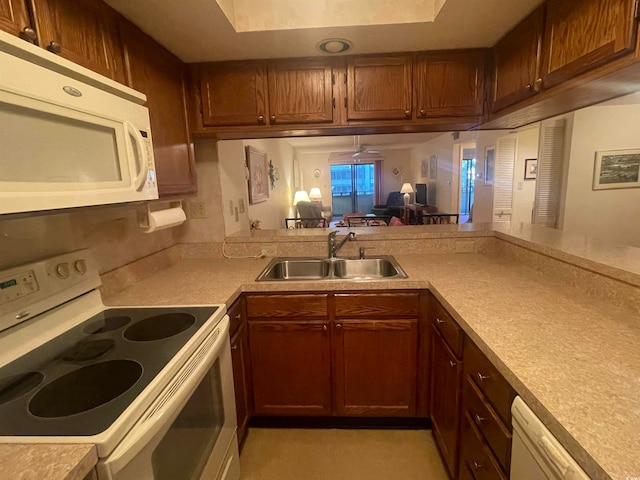 kitchen with white appliances, ceiling fan, kitchen peninsula, and sink