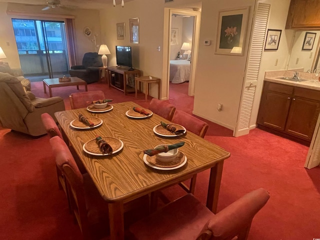 carpeted dining room featuring sink and ceiling fan