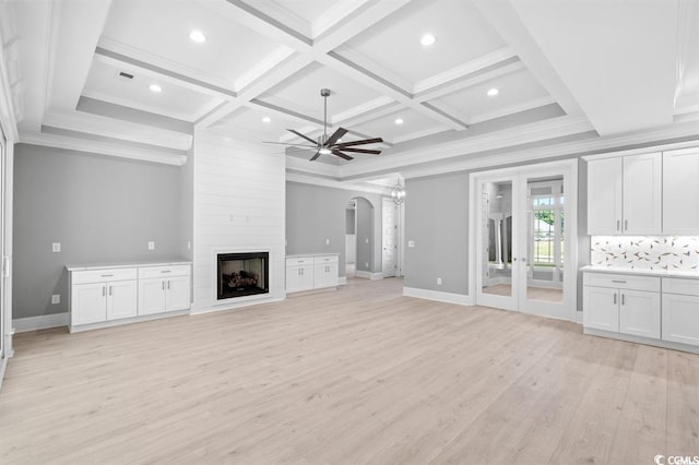 unfurnished living room featuring coffered ceiling, ceiling fan, a large fireplace, and light hardwood / wood-style floors