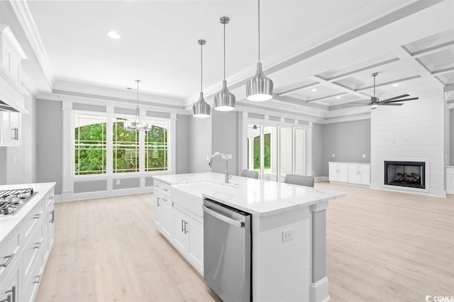 kitchen with light wood-type flooring, coffered ceiling, a kitchen island with sink, and stainless steel appliances