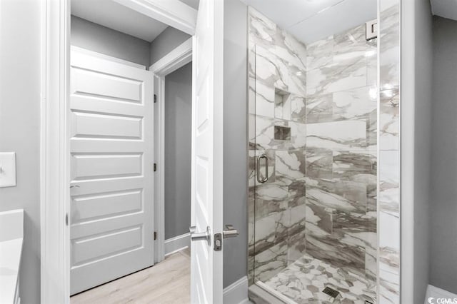 bathroom with hardwood / wood-style floors and a shower with door