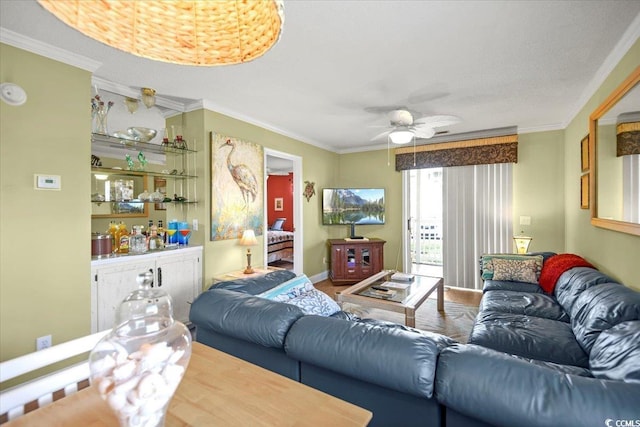 living area with a ceiling fan and ornamental molding