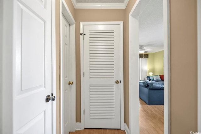 corridor featuring crown molding and light wood-style floors