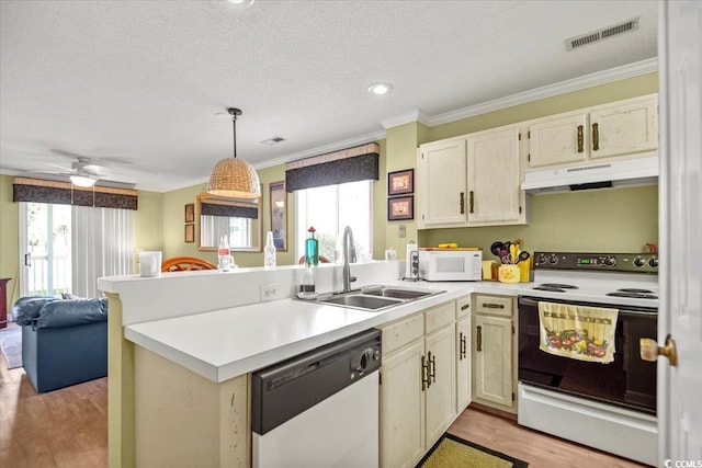 kitchen featuring visible vents, under cabinet range hood, white appliances, a peninsula, and light countertops