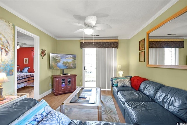 living area with baseboards, a healthy amount of sunlight, wood finished floors, and ornamental molding