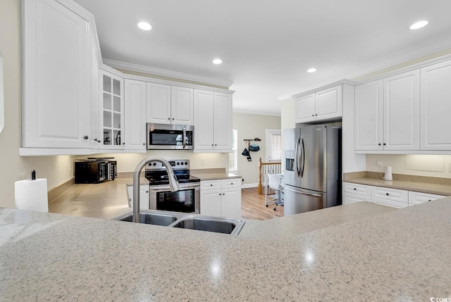 kitchen with crown molding, appliances with stainless steel finishes, a sink, and recessed lighting