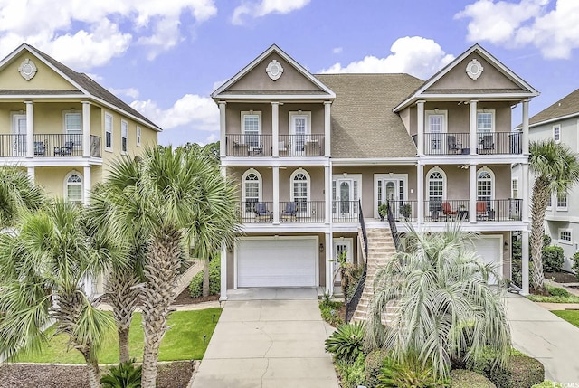 view of front of house featuring driveway, stairway, an attached garage, and stucco siding