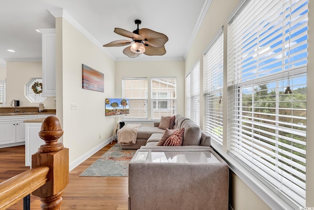 sunroom featuring ceiling fan and a sink