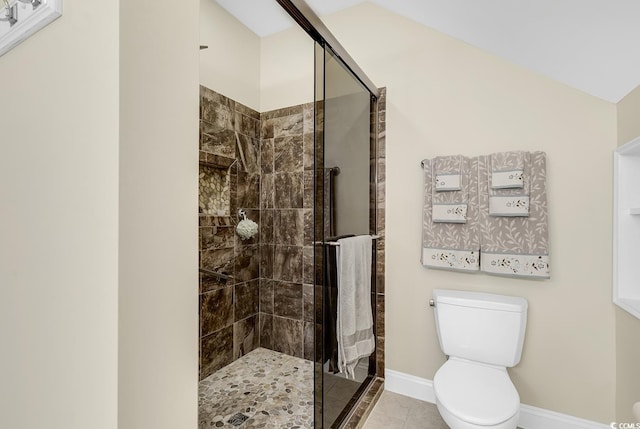 full bath featuring toilet, a shower stall, baseboards, and tile patterned floors