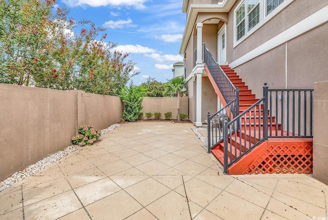 view of patio with stairway and a fenced backyard