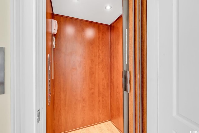 details featuring elevator, wood finished floors, and recessed lighting