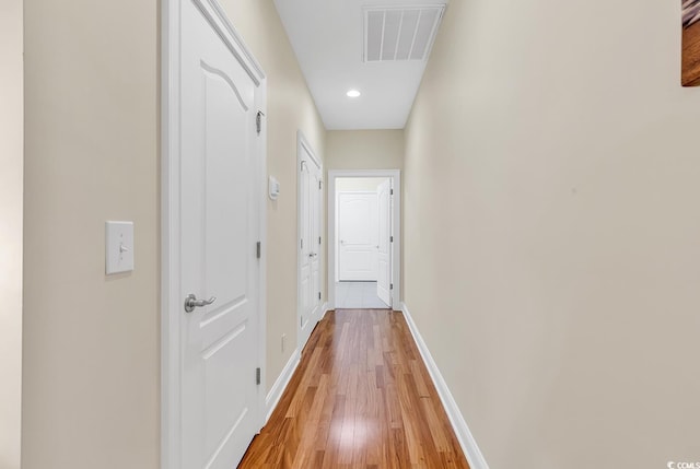 hallway featuring recessed lighting, visible vents, light wood finished floors, and baseboards