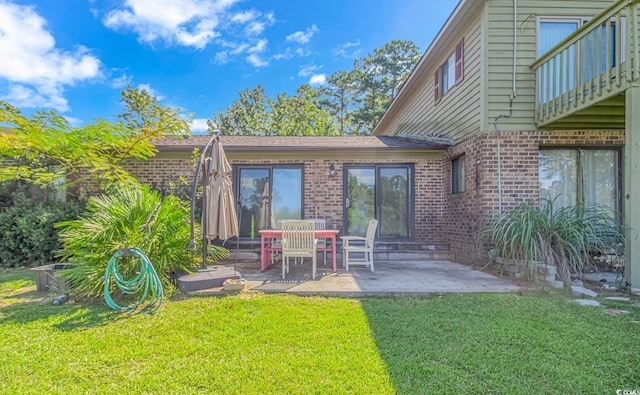 305 Resort Dr Unit C12, Myrtle Beach, SC 29588 - back of house with brick siding, a lawn, and a patio area