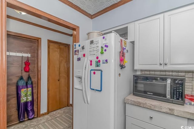 kitchen featuring white refrigerator with ice dispenser, crown molding, light tile patterned floors, decorative backsplash, and white cabinets