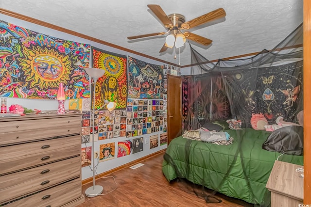 bedroom with a textured ceiling, ceiling fan, ornamental molding, and hardwood / wood-style floors