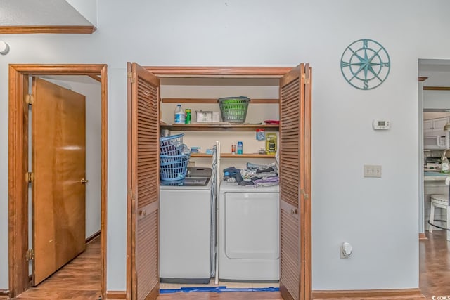 laundry room featuring light wood-type flooring and washer and clothes dryer