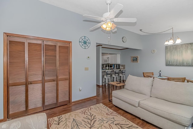 living room with ceiling fan with notable chandelier and wood-type flooring