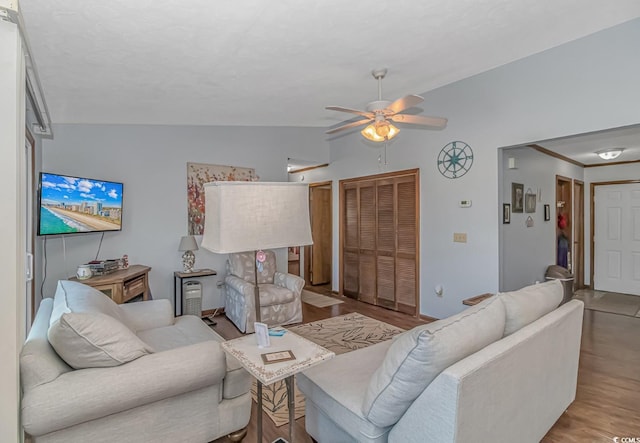 living room featuring light hardwood / wood-style flooring, ceiling fan, and vaulted ceiling