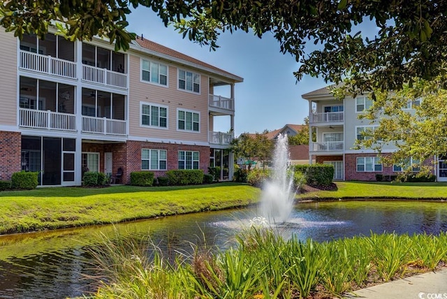 view of property's community featuring a water view and a lawn