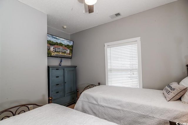 bedroom featuring ceiling fan and a textured ceiling