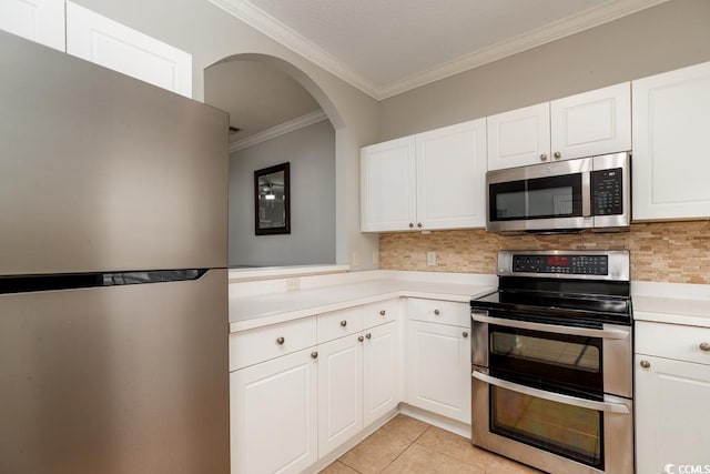 kitchen featuring tasteful backsplash, appliances with stainless steel finishes, light tile patterned floors, and white cabinets