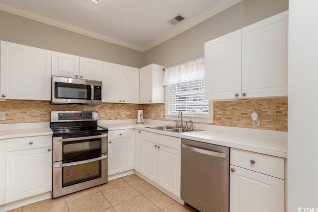 kitchen with sink, appliances with stainless steel finishes, white cabinetry, ornamental molding, and decorative backsplash