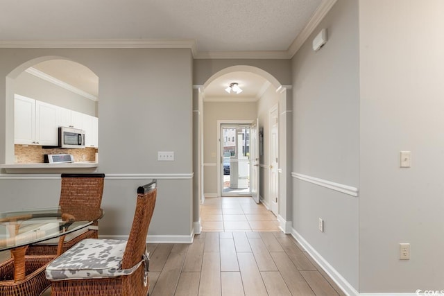 corridor featuring ornamental molding and light hardwood / wood-style floors