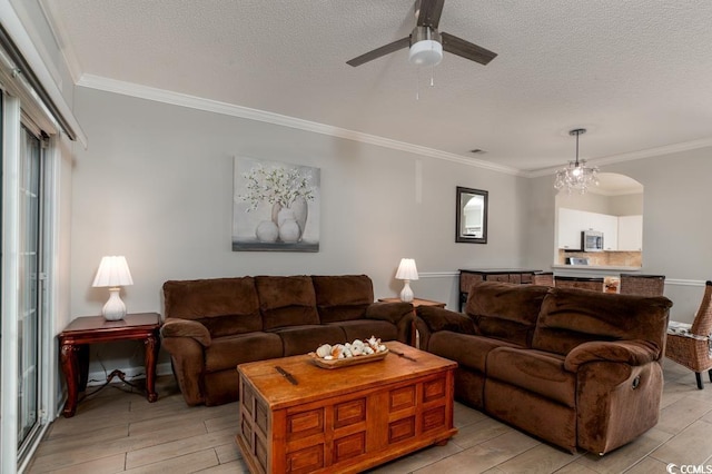 living room with ornamental molding, ceiling fan, and a textured ceiling