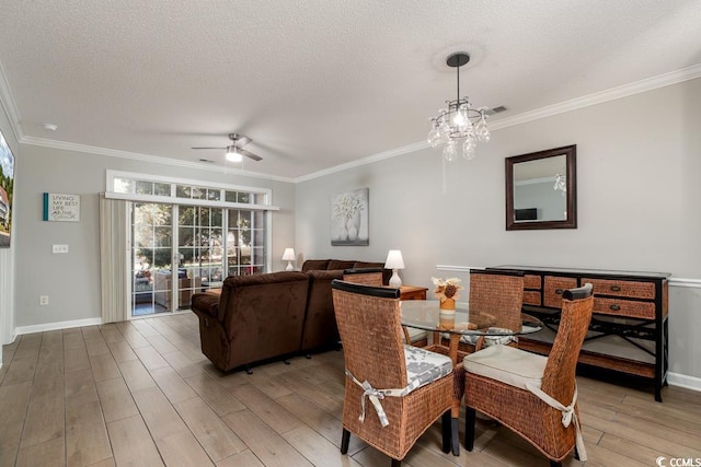 dining area with hardwood / wood-style floors, crown molding, ceiling fan with notable chandelier, and a textured ceiling