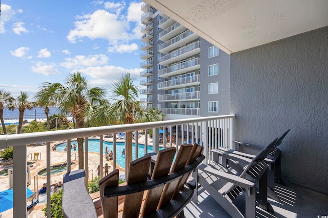 balcony featuring a water view and a hot tub