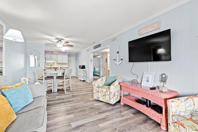 living room with crown molding, hardwood / wood-style floors, and ceiling fan