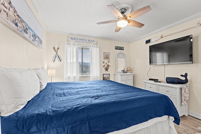 bedroom with crown molding, a textured ceiling, light hardwood / wood-style flooring, and ceiling fan