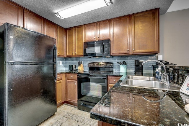 kitchen with brown cabinets, decorative backsplash, a sink, a textured ceiling, and black appliances