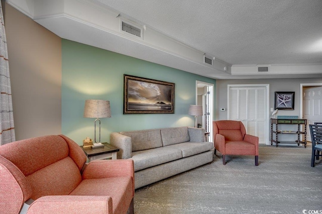 living room with a textured ceiling, visible vents, and carpet flooring