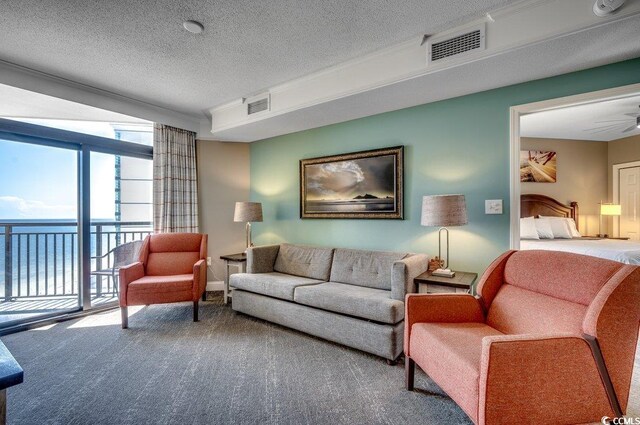 living room with carpet flooring, ceiling fan, and a textured ceiling