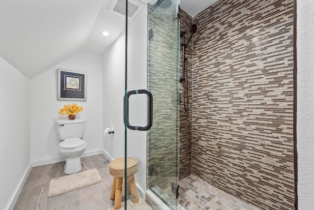 bathroom featuring a shower with door, toilet, tile patterned floors, and lofted ceiling