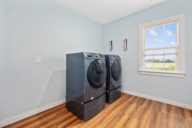 laundry area with washing machine and clothes dryer and wood-type flooring