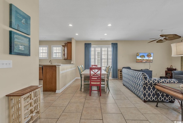 dining space featuring a textured ceiling, light tile patterned flooring, and ceiling fan