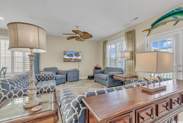 living room featuring ceiling fan and a healthy amount of sunlight