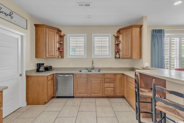 kitchen with dishwasher, sink, and light tile patterned floors