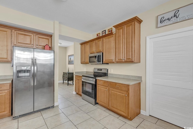 kitchen with light tile patterned floors and stainless steel appliances