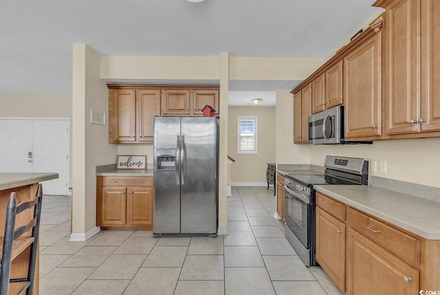 kitchen featuring stainless steel appliances and light tile patterned flooring