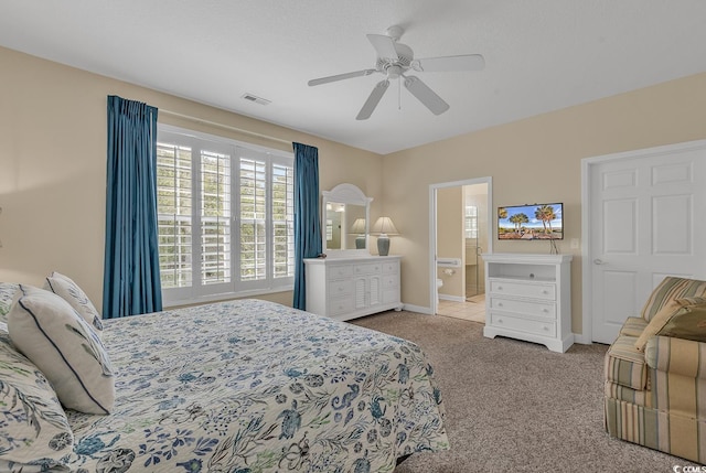 bedroom with light carpet, ensuite bathroom, and ceiling fan