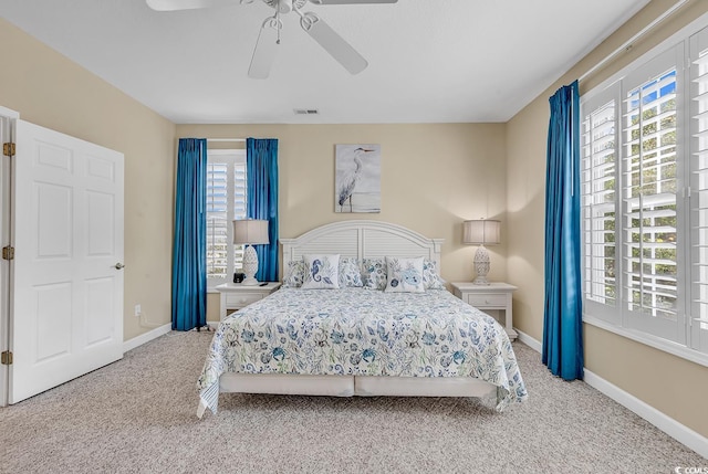 carpeted bedroom featuring ceiling fan and multiple windows