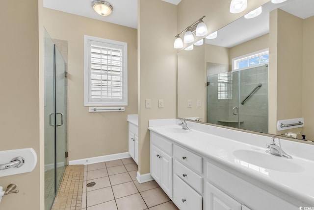 bathroom featuring vanity, a healthy amount of sunlight, and a shower with door