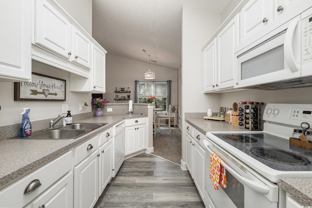 kitchen featuring pendant lighting, hardwood / wood-style flooring, white cabinets, lofted ceiling, and white appliances