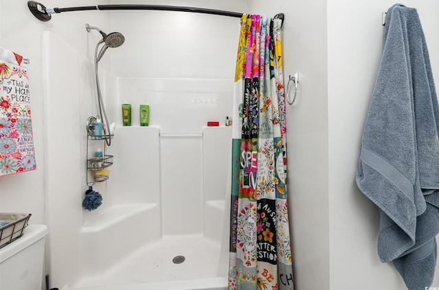 bathroom featuring toilet and curtained shower