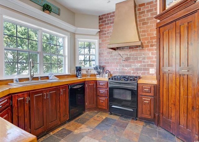 kitchen featuring ornamental molding, a notable chandelier, stainless steel fridge, and decorative light fixtures