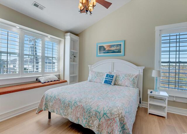 bedroom featuring light hardwood / wood-style flooring, vaulted ceiling, and ceiling fan