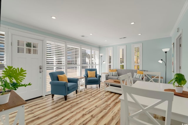 living room with light wood-type flooring and crown molding